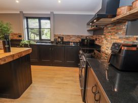 A kitchen with appliances and a window at Holly Farm in Brantham