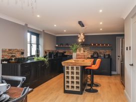 A kitchen with a black countertop and island at Holly Farm in Brantham