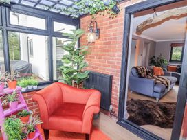A conservatory with a chair and plants at Holly Farm in Brantham