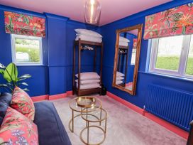 A bedroom with a couch and mirror at Holly Farm in Brantham