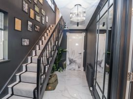 A hallway with a staircase and wall decor at Holly Farm in Brantham