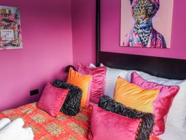 A bed with colorful pillows in a bedroom at Holly Farm in Brantham