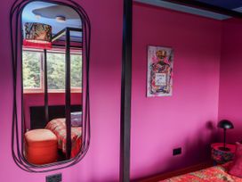 A bedroom with a mirror and colorful decor at Holly Farm in Brantham