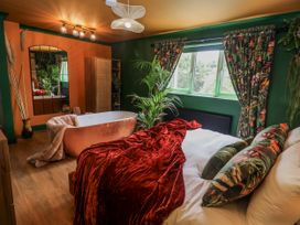 A bedroom with a bed and a bathtub at Holly Farm in Brantham
