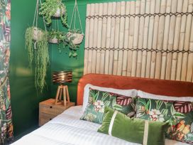 A bedroom with a bed and hanging plants at Holly Farm in Brantham