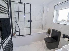 A bathroom with a shower, bathtub, and toilet at Holly Farm in Brantham