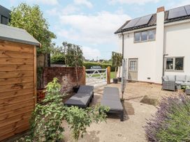 An outdoor area with lounge chairs and a shed at Holly Farm in Brantham