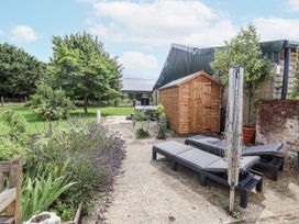 A garden with sun loungers and a shed at Holly Farm in Brantham