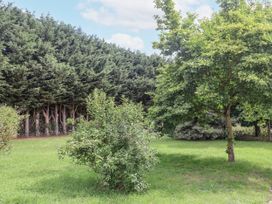 A garden with grass and trees at Holly Farm in Brantham