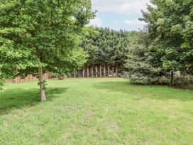 A garden with trees and grass at Holly Farm in Brantham