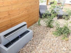 A garden with a water feature and gravel at Holly Farm in Brantham