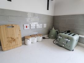 A kitchen counter with a toaster, kettle, and storage jars at Annexe in Colchester