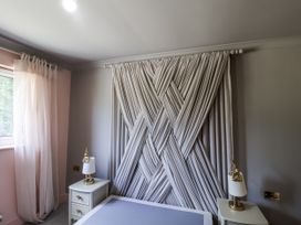 A bedroom with curtains and a bed at Annexe in Colchester