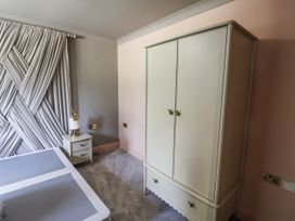 A bedroom with a bed and a wardrobe at Annexe in Colchester
