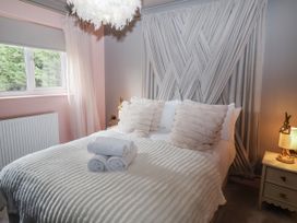 A bedroom with a bed and decorative cushions at Annexe, East End near Brantham