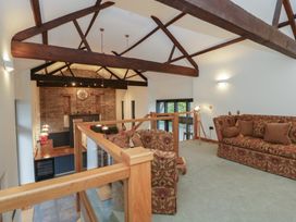 A living room with sofas and a wall clock at The Barn at Sunny Barn Brecon