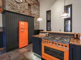 A kitchen with an orange refrigerator and oven at The Barn at Sunny Barn in Brecon