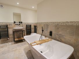 A bathroom with bathtub and washbasin at The Barn at Sunny Barn Brecon