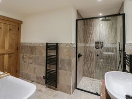 A bathroom with a shower and bathtub at The Barn at Sunny Barn Brecon