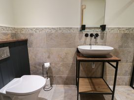 A bathroom with a toilet and a wash basin at The Barn at Sunny Barn Brecon