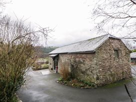 A stone building with a roof and pathway at The Barn at Sunny Barn Brecon