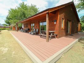 A log cabin with a deck and outdoor seating at Sunnyside Lodge in Thorpe-On-The-Hill