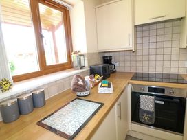 A kitchen with a window and appliances at Sunnyside Lodge in Thorpe-On-The-Hill