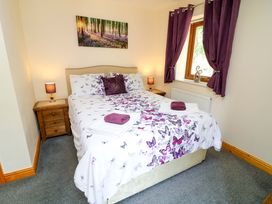 A bedroom with a bed and nightstand at Sunnyside Lodge in Thorpe-On-The-Hill