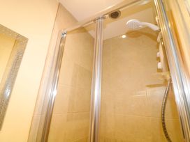 A shower enclosure with glass doors and shower head at Sunnyside Lodge in Thorpe-On-The-Hill