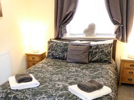 A bedroom with a bed, bedside tables and lamps at Sunnyside Lodge in Thorpe-On-The-Hill