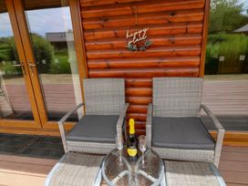 An outdoor seating area with chairs and a table at Sunnyside Lodge Thorpe-On-The-Hill