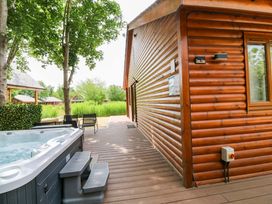 An outdoor area with a hot tub and wooden cabin at Sunnyside Lodge in Thorpe-On-The-Hill
