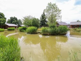 View of cabins surrounding a pond at Sunnyside Lodge in Thorpe-On-The-Hill