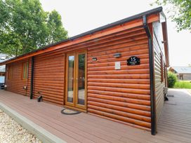 A log cabin with double doors and a number sign at Sunnyside Lodge in Thorpe-On-The-Hill