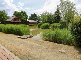 An outdoor view with houses around a pond at Sunnyside Lodge in Thorpe-On-The-Hill