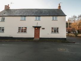 A house with a door and windows at Vine Cottage in Alderton