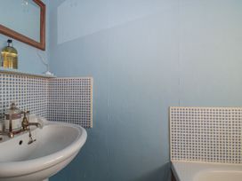 A bathroom with a sink and mirror at Vine Cottage Alderton