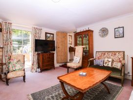 A living room with a television and armchairs at Vine Cottage in Cheltenham