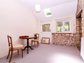 A snug with a table and chairs at Vine Cottage in Cheltenham