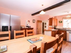 A kitchen with a dining table and refrigerator at Vine Cottage Cheltenham