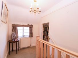 A hallway with a table and a vase at Vine Cottage in Cheltenham