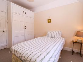 A bedroom with a bed and wardrobe at Vine Cottage in Cheltenham