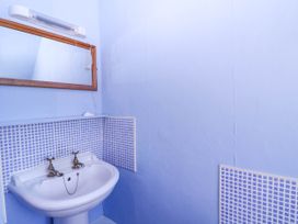 A bathroom with a sink and mirror at Vine Cottage in Cheltenham