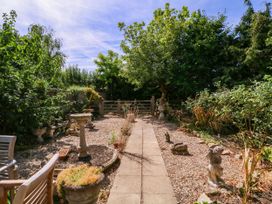 A garden with a path leading to a gate at Vine Cottage in Cheltenham