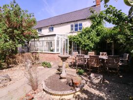 A garden with a bird bath and seating area at Vine Cottage in Cheltenham
