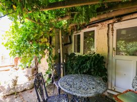 A table with chairs beside a door at Vine Cottage in Cheltenham