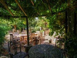 A garden with tables and chairs at Vine Cottage in Cheltenham