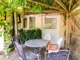 A garden area with a table and chairs at Vine Cottage in Cheltenham