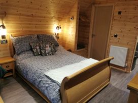 A bedroom with a bed and bedside table at Lodge 2 Pontyates