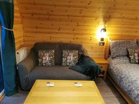 A bedroom with a sofa and a bed at Lodge 2 Pontyates